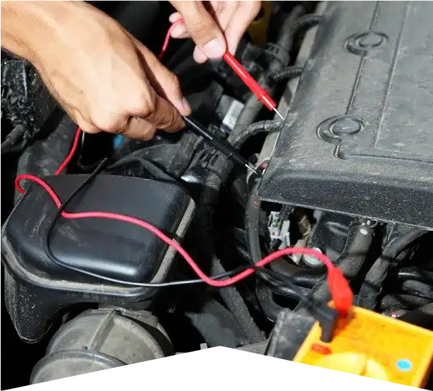 ADAS Services & Electrical Repair in Clive, IA At Westside Auto Pros. A person uses a multimeter with red and black probes to test an electrical component under the hood of a car. The engine and battery are visible.