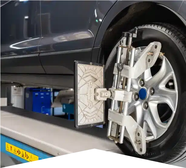 Wheel Alignments in Clive, IA At Westside Auto Pros. A close-up view of a car wheel mounted on an alignment machine in an auto repair shop, showing the equipment used for wheel alignment.