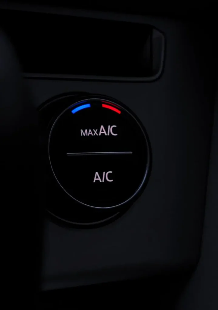 Auto Air Conditioning & Heat Repair in Clive, IA At Westside Auto Pros. A close-up of a car air conditioning control knob, showing blue and red markings for temperature, with the words MAX A/C and A/C illuminated on a dark dashboard.