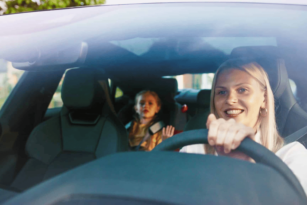 National Car Care Month in Clive, IA: A Smarter Way to Prevent Breakdowns by Westside Auto Pros -- a woman and her kid in a car enjoying a well-maintained car on a drive