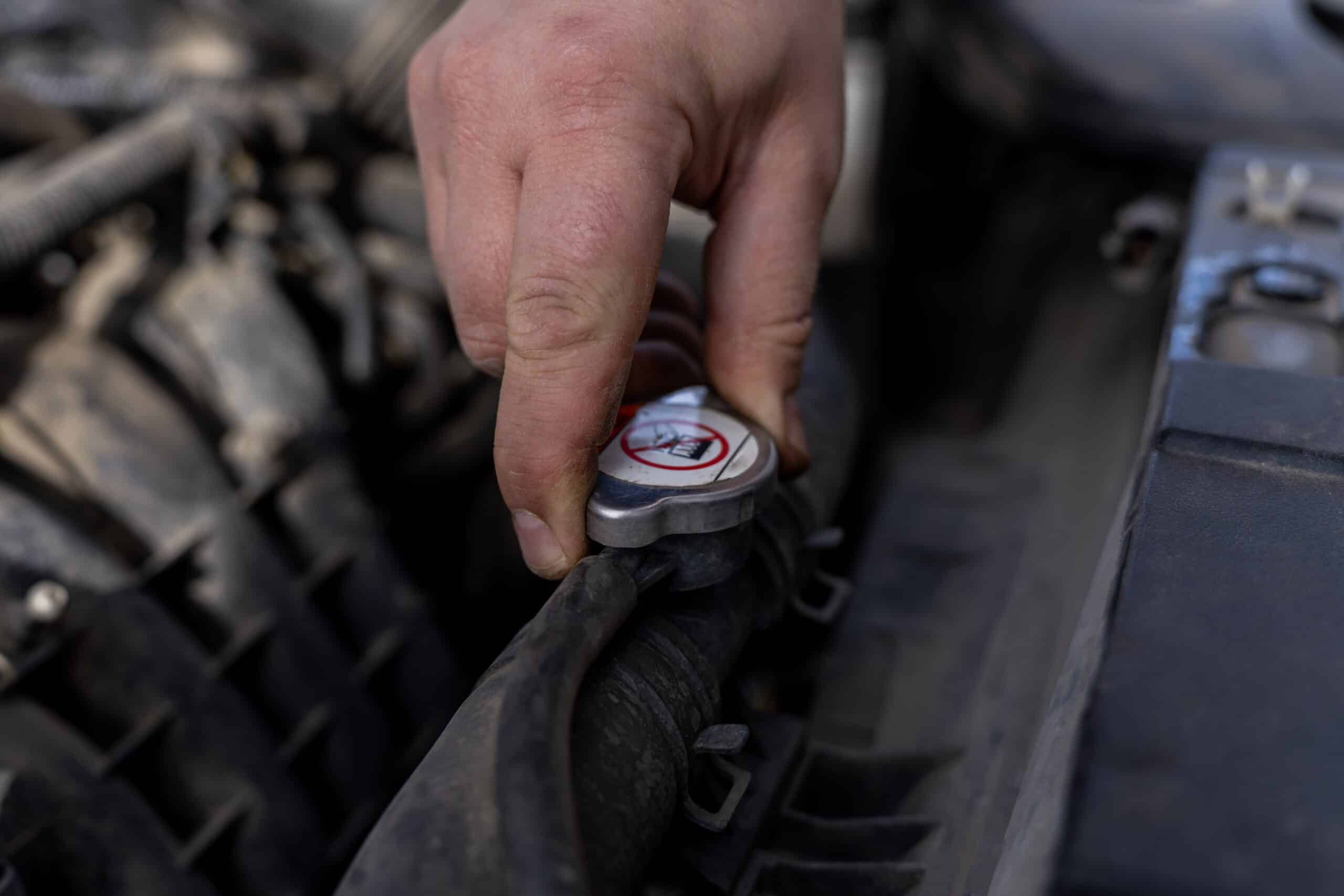 Radiator and Cooling System Service in Clive, IA by Westside Auto Pros, close up of mechanic inspecting a radiator's cap
